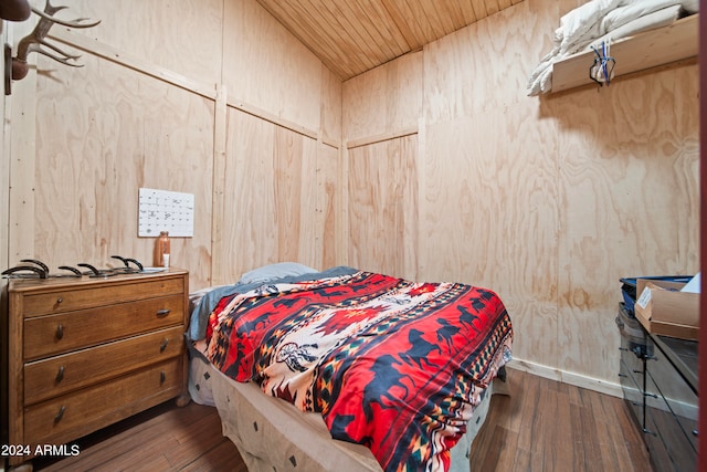 bedroom featuring dark hardwood / wood-style floors, wood walls, and wooden ceiling