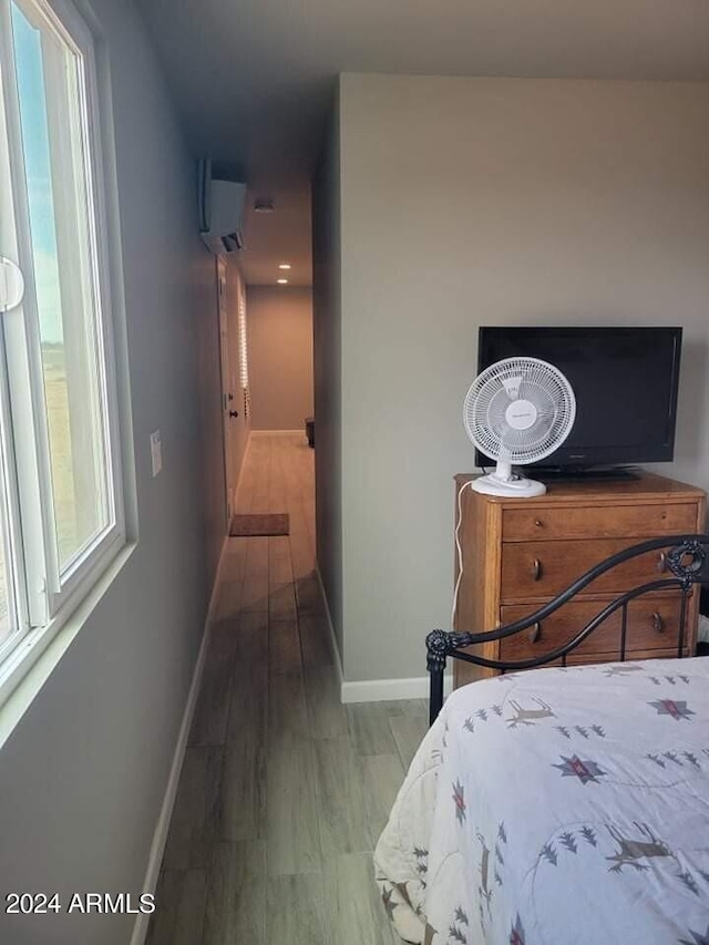 bedroom with an AC wall unit and wood-type flooring