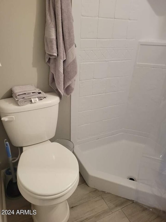 bathroom featuring toilet and tiled shower