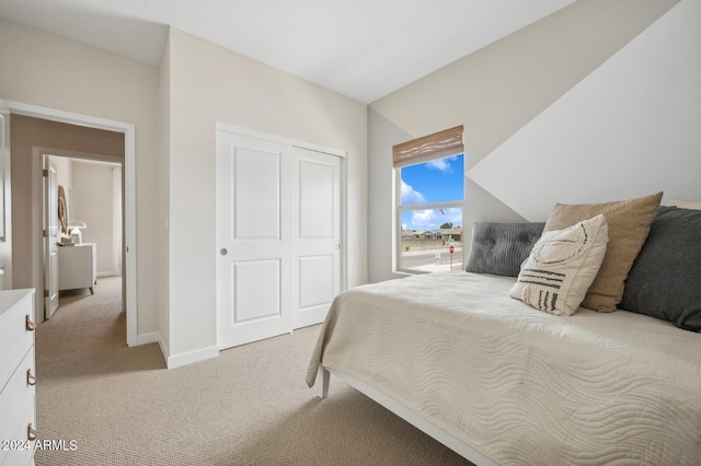 bedroom with light carpet, a closet, and baseboards