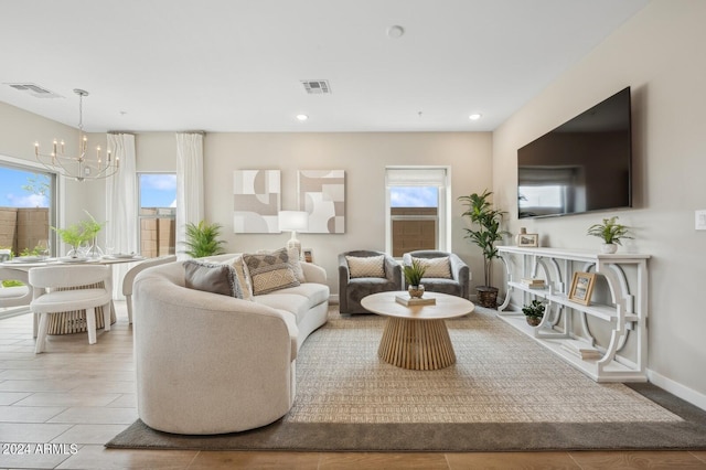 living room featuring baseboards, visible vents, a notable chandelier, and recessed lighting