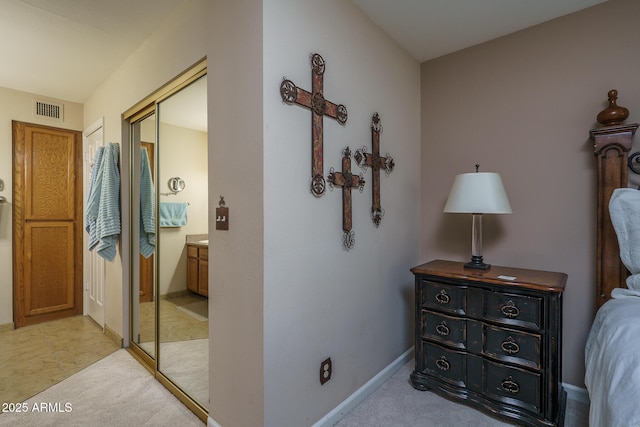 bedroom with baseboards, a closet, visible vents, and light colored carpet