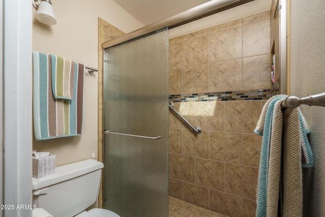 full bath featuring a stall shower and toilet