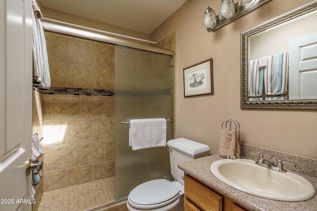 bathroom featuring a stall shower, vanity, and toilet