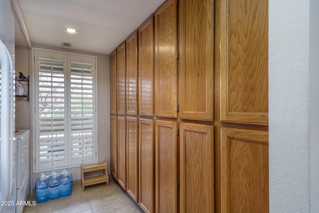 interior space featuring visible vents, washing machine and clothes dryer, and light tile patterned floors