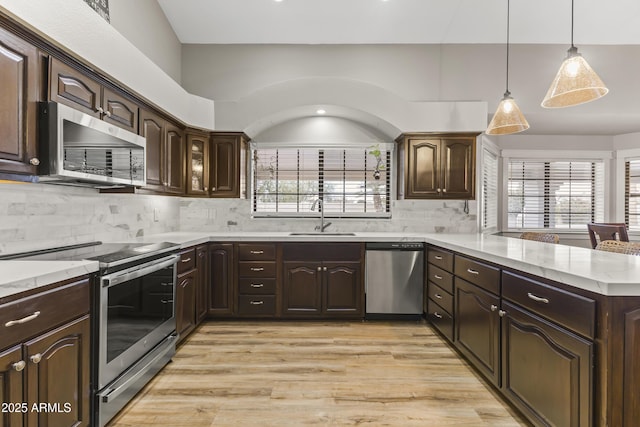 kitchen featuring decorative backsplash, stainless steel appliances, sink, and dark brown cabinets