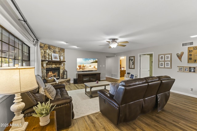 living room with hardwood / wood-style floors, a fireplace, and ceiling fan