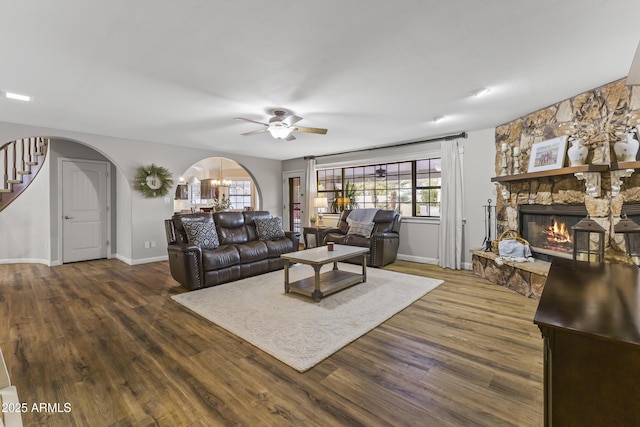 living room with dark hardwood / wood-style flooring, a fireplace, and ceiling fan