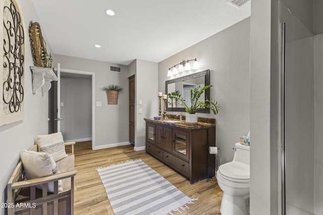 bathroom featuring vanity, toilet, and hardwood / wood-style floors