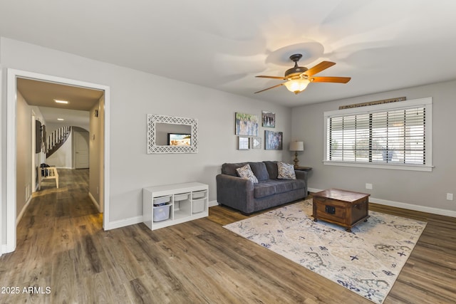 living room featuring ceiling fan and dark hardwood / wood-style floors