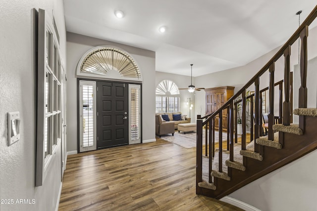 foyer with dark wood-type flooring, plenty of natural light, high vaulted ceiling, and ceiling fan