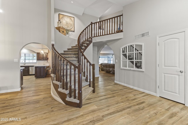 entrance foyer featuring a towering ceiling and light hardwood / wood-style flooring