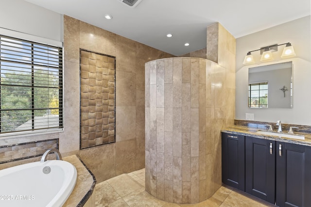 bathroom with independent shower and bath, vanity, tile walls, and tile patterned floors