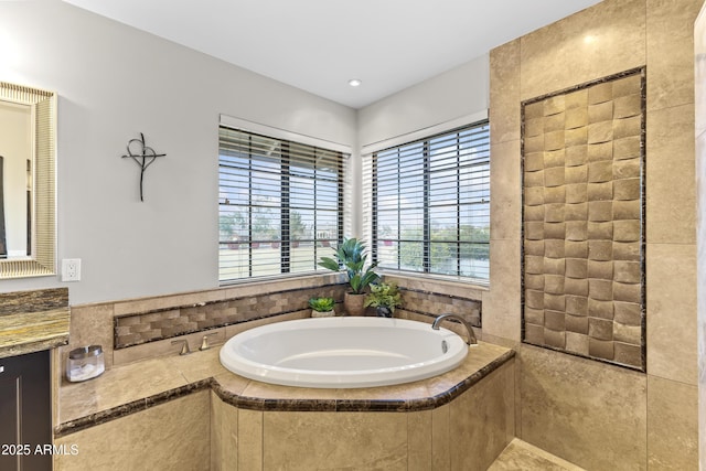 bathroom with vanity, a water view, and a relaxing tiled tub