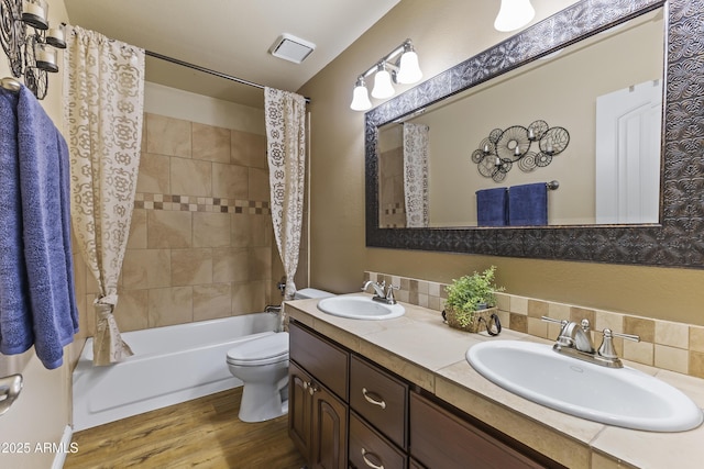 full bathroom with hardwood / wood-style flooring, backsplash, vanity, shower / bath combination with curtain, and toilet