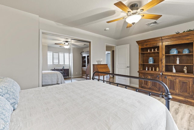 bedroom featuring light wood-type flooring, ceiling fan, and a closet