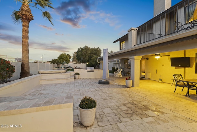 view of patio / terrace featuring ceiling fan, a balcony, and exterior kitchen