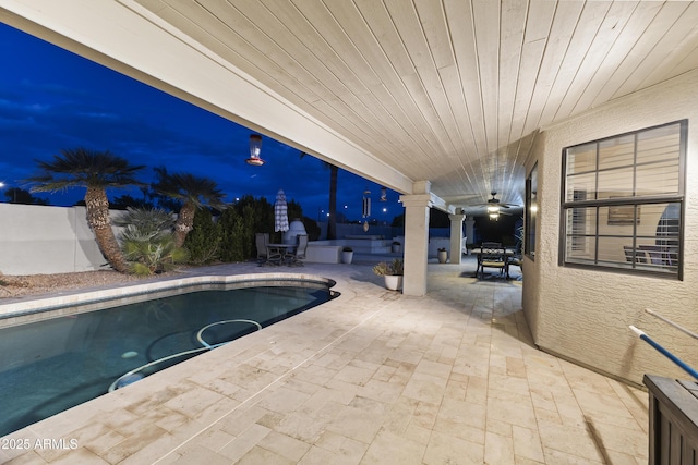 pool at dusk featuring decorative columns