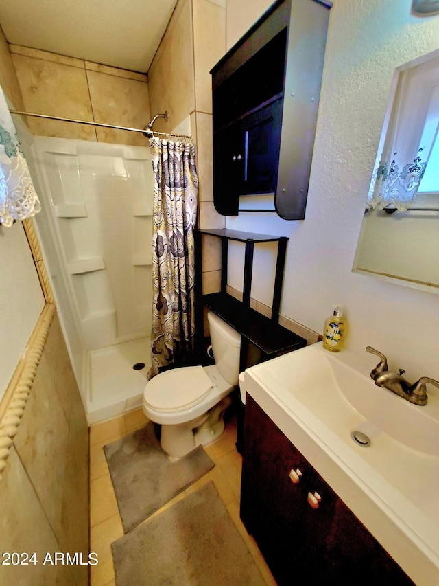 bathroom featuring tile patterned flooring, curtained shower, toilet, and vanity