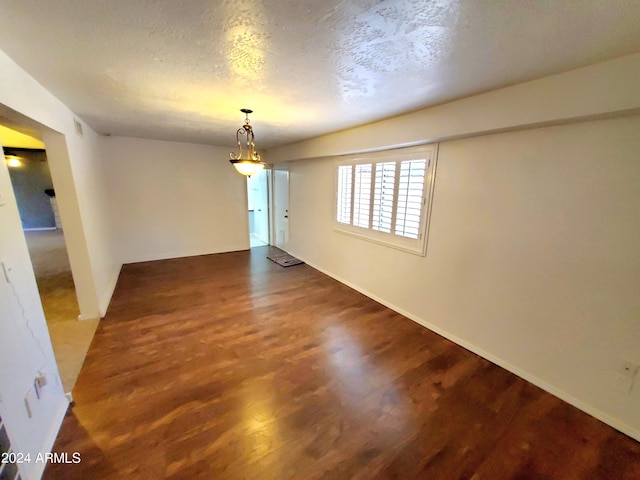 unfurnished room with hardwood / wood-style floors and a textured ceiling