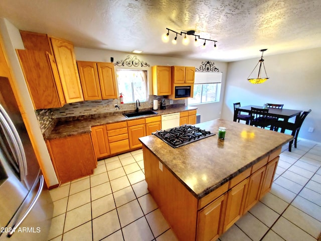 kitchen featuring backsplash, a healthy amount of sunlight, sink, and a kitchen island