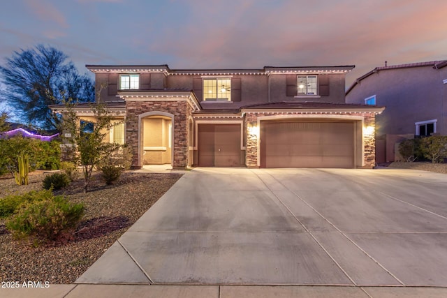 mediterranean / spanish home featuring a garage, stone siding, driveway, and stucco siding