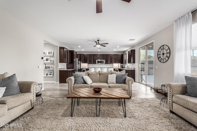 living area featuring recessed lighting, visible vents, ceiling fan, and light wood finished floors