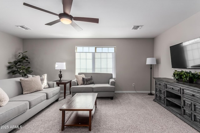 living room with carpet flooring, ceiling fan, visible vents, and baseboards