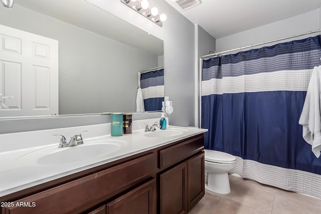 bathroom featuring toilet, a sink, visible vents, and tile patterned floors