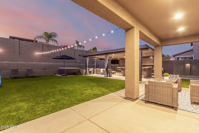 view of patio with an outdoor hangout area, exterior kitchen, a fenced backyard, and a hot tub