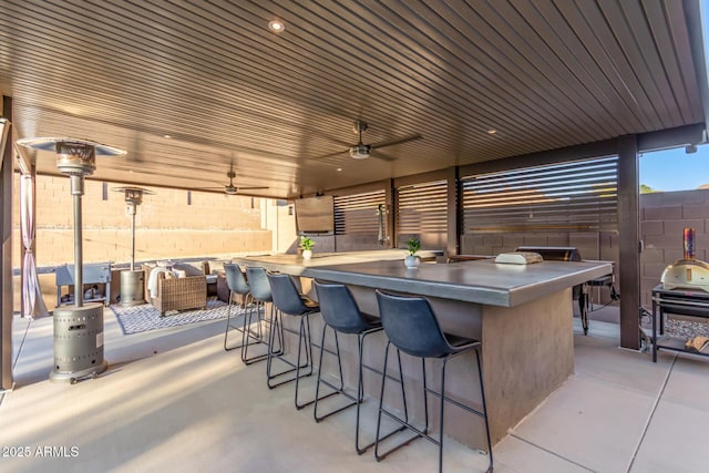 view of patio / terrace with a ceiling fan and an outdoor bar