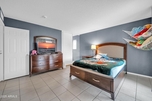 bedroom with light tile patterned flooring and a textured ceiling