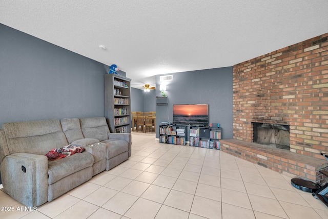 living room featuring a brick fireplace, light tile patterned floors, and a textured ceiling