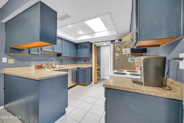 kitchen featuring sink, light tile patterned floors, stainless steel appliances, a tray ceiling, and blue cabinets