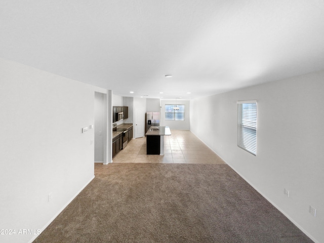 unfurnished living room featuring a healthy amount of sunlight and light colored carpet