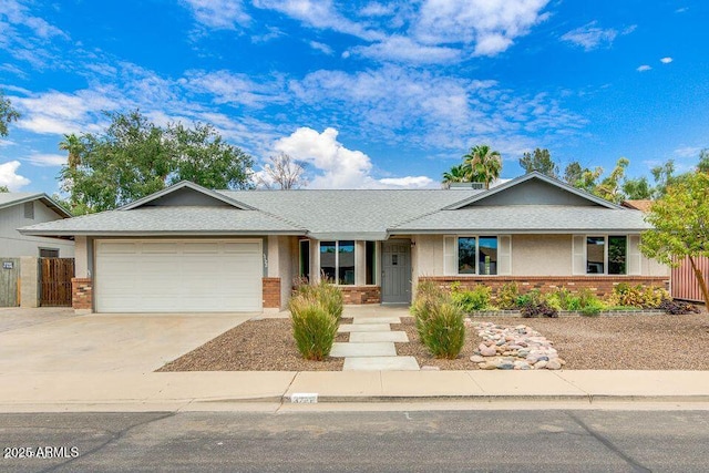 ranch-style house with a garage, brick siding, concrete driveway, and roof with shingles