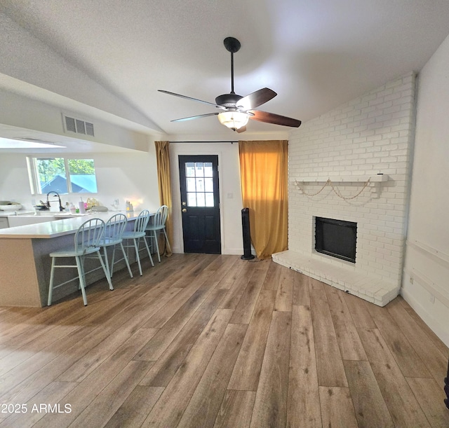 3722 E Glade Ave, Mesa, AZ 85206 - living area featuring lofted ceiling, wood finished floors, a ceiling fan, and a fireplace