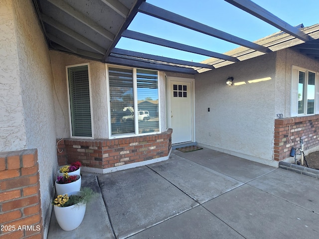 3722 E Glade Ave, Mesa, AZ 85206 - view of exterior entry with brick siding, a patio area, and stucco siding