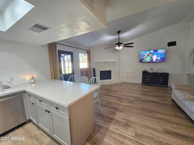 3722 E Glade Ave, Mesa, AZ 85206 - kitchen with open floor plan, a brick fireplace, light wood-type flooring, vaulted ceiling, and a peninsula