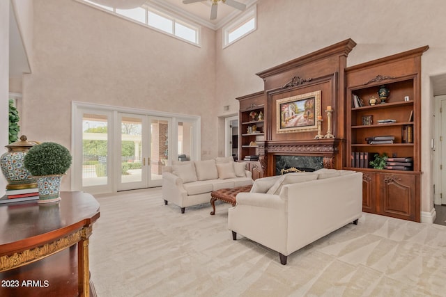 living area featuring light carpet, a fireplace, a wealth of natural light, and french doors