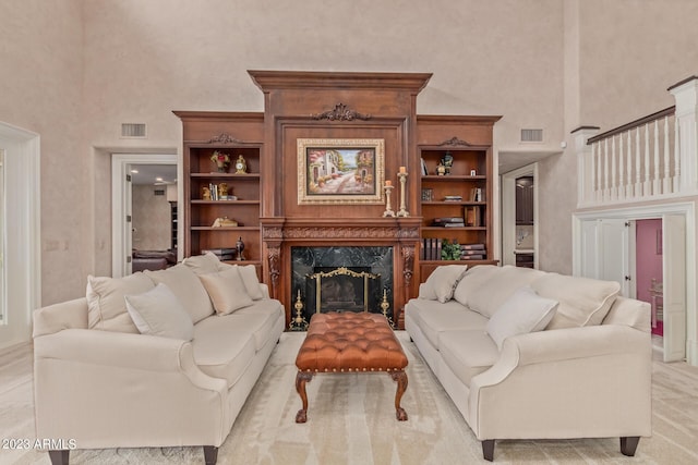 living room featuring visible vents, a fireplace, and a high ceiling