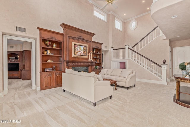 living area featuring crown molding, light colored carpet, visible vents, stairway, and a high end fireplace