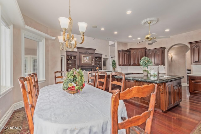 dining area with arched walkways, recessed lighting, ceiling fan with notable chandelier, dark wood-type flooring, and baseboards