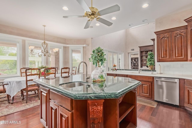 kitchen with stainless steel dishwasher, dark wood-style flooring, a sink, and an island with sink