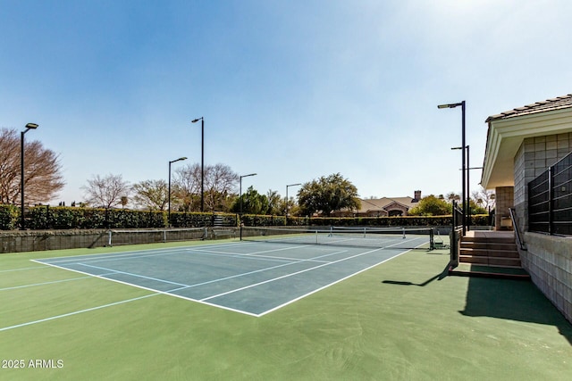 view of tennis court featuring fence