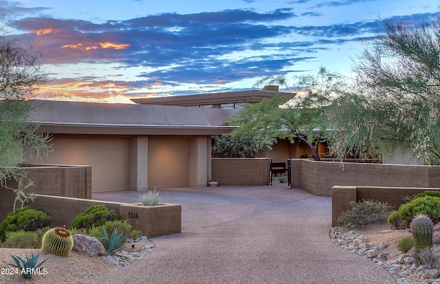 patio terrace at dusk featuring a garage and an outdoor structure