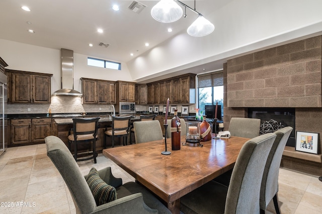 9216 E Sky Line Dr, Scottsdale, AZ 85262 - dining area with recessed lighting, plenty of natural light, high vaulted ceiling, and a glass covered fireplace