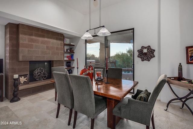 dining room featuring a fireplace and a towering ceiling