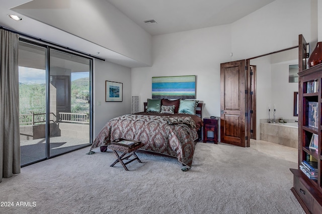 bedroom with access to exterior, light colored carpet, and connected bathroom