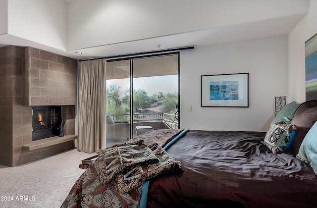 bedroom with carpet flooring, access to outside, and a fireplace